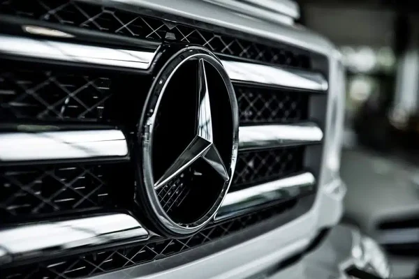 Close-up of the chrome Mercedes-Benz star emblem on the front grille of a vehicle, representing luxury makes like the S430 or S500 that require specific under-hood ECM location guides.